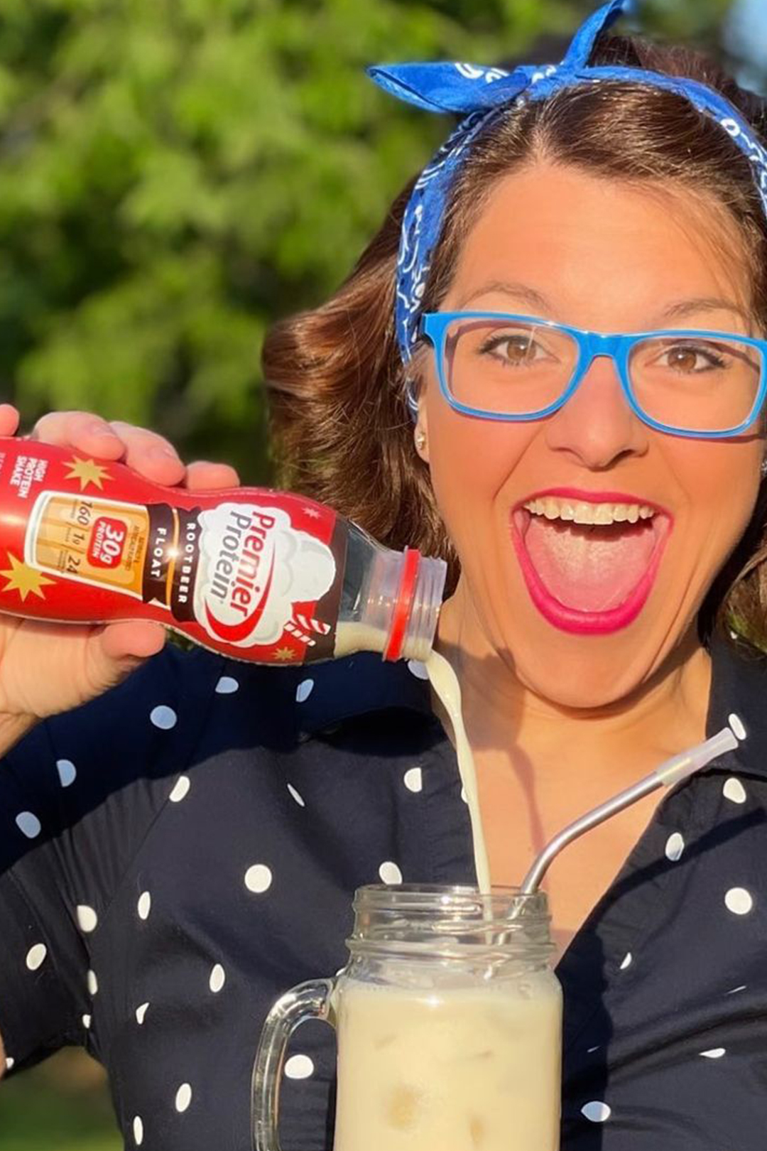 Smiling woman pouring Premier Protein Root Beer Float shake into a glass